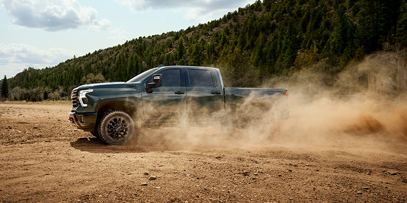2026 Silverado HD driving through dirt near mountains near Medford, OR.